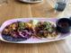 An artistic arrangement of tacos topped with fresh vegetables served with a lime wedge and dipping sauce at 10373 W 75Th Ave, Arvada, CO 80005