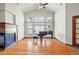 Spacious living room featuring hardwood floors, a fireplace, high ceilings, and a piano at 1513 Cannon Mountain Dr, Longmont, CO 80503