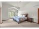 Comfortable bedroom with a large window offering tree views, vaulted ceilings, and a cozy, carpeted floor at 1513 Cannon Mountain Dr, Longmont, CO 80503