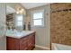 Bathroom with updated vanity and granite countertops along with tiled shower and tub at 7301 Dale Ct, Westminster, CO 80030