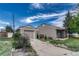 Exterior view showcasing a detached garage, home, covered porch and driveway under a sunny sky at 7301 Dale Ct, Westminster, CO 80030