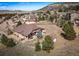 Aerial view of a home surrounded by mature trees and mountains in the background at 20217 Kenneth Lainer Dr, Monument, CO 80132