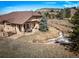 Aerial view showcasing the home's backyard, stone landscaping, and inviting outdoor patio at 20217 Kenneth Lainer Dr, Monument, CO 80132