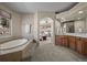 Bathroom showing a large tub, vanity and an arched doorway leading into the bedroom at 20217 Kenneth Lainer Dr, Monument, CO 80132