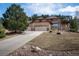 Well-maintained home featuring mature trees, a three-car garage, and a spacious driveway at 20217 Kenneth Lainer Dr, Monument, CO 80132