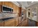 This kitchen features stainless steel appliances, granite countertops, hardwood floors, and custom cabinetry at 20217 Kenneth Lainer Dr, Monument, CO 80132