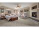 The main bedroom features carpet flooring, a ceiling fan, a fireplace, and plenty of natural light at 20217 Kenneth Lainer Dr, Monument, CO 80132