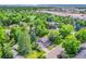 An impressive neighborhood view showcases the home with lush trees and cityscape in the background at 6721 S Clayton Way, Centennial, CO 80122