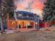 Backyard with covered patio and grassy area, illuminated by a colorful sunset at 6721 S Clayton Way, Centennial, CO 80122