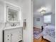 Bathroom with a modern LED mirror, marble countertop, and access to a well-lit bedroom with hardwood floors at 6721 S Clayton Way, Centennial, CO 80122
