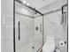 Updated bathroom with a sleek glass shower enclosure, white marble style tile, and a modern toilet at 6721 S Clayton Way, Centennial, CO 80122