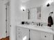 Bathroom featuring a double sink vanity with a white countertop and a large mirror with updated fixtures at 6721 S Clayton Way, Centennial, CO 80122