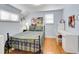 Cozy bedroom showcasing a full-sized bed, a desk area, hardwood floors, and well-lit with windows at 6721 S Clayton Way, Centennial, CO 80122