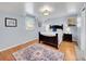 Comfortable bedroom with hardwood floors, a large bed with an intricate headboard, and natural light from two windows at 6721 S Clayton Way, Centennial, CO 80122