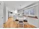 Open kitchen and dining area with white cabinets, stainless steel appliances, and hardwood floors at 6721 S Clayton Way, Centennial, CO 80122