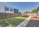 Fenced backyard with green lawn and a trampoline, providing a secure play area at 3695 E Dartmouth Ave, Denver, CO 80210