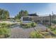 Backyard featuring a garden with a water feature, plus a black garage and sport court at 3695 E Dartmouth Ave, Denver, CO 80210