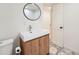 Modern bathroom with a square sink, wood vanity, round mirror and geometric tile at 3695 E Dartmouth Ave, Denver, CO 80210