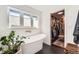 Bright bathroom featuring a freestanding tub and a view into the closet with organized storage at 3695 E Dartmouth Ave, Denver, CO 80210