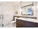 Modern bathroom featuring marble tile, a dark wood vanity, pendant lights, and glass enclosed shower at 3695 E Dartmouth Ave, Denver, CO 80210