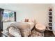 Cozy bedroom with decor pillow, soft throw blanket, and curated bookshelf, exuding warmth at 3695 E Dartmouth Ave, Denver, CO 80210