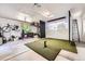 Finished garage features a golf simulator setup with screen, projector, and putting green at 3695 E Dartmouth Ave, Denver, CO 80210