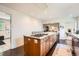 Kitchen island features a gas cooktop, seating, and a view into the dining room at 3695 E Dartmouth Ave, Denver, CO 80210