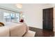 Bright main bedroom with sliding door access to patio, hardwood floors and neutral decor at 3695 E Dartmouth Ave, Denver, CO 80210