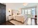 Comfortable bedroom with a plush bed, dark hardwood floors, and a sliding door to the outside at 3695 E Dartmouth Ave, Denver, CO 80210