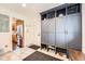 Well-organized mudroom with blue storage cabinets, shoe racks, and a view into the adjacent kitchen at 3695 E Dartmouth Ave, Denver, CO 80210