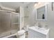 Bright, updated bathroom features a glass-enclosed shower, modern vanity, and neutral color palette at 4073 S Liverpool St, Aurora, CO 80013