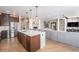 Open-concept kitchen featuring stainless steel appliances, island with seating, and easy flow into the living room at 4073 S Liverpool St, Aurora, CO 80013