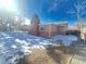 Brick home with backyard, snow, and trees at 1120 Tucson St, Aurora, CO 80011