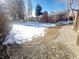 View of a beautiful backyard in the winter with manicured gravel, some snow and brick home at 1120 Tucson St, Aurora, CO 80011