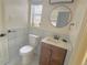 Small bathroom with brown vanity and round mirror at 1120 Tucson St, Aurora, CO 80011