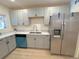 This remodeled kitchen features gray cabinets, marble countertops, stainless steel appliances and new vinyl flooring at 1120 Tucson St, Aurora, CO 80011