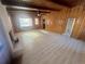 Bright living room featuring wood paneled walls, beam ceilings, and a brick fireplace at 1120 Tucson St, Aurora, CO 80011