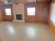 Bright living room featuring wood paneled walls, beam ceilings, and a brick fireplace at 1120 Tucson St, Aurora, CO 80011