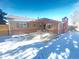 View of a brick patio with a patio table in the backyard of a brick home with a wooden covering at 1120 Tucson St, Aurora, CO 80011