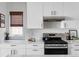 White kitchen with stainless steel appliances and subway tile backsplash at 3422 S Grant St, Englewood, CO 80113