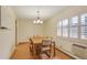 Bright dining room with a wood table set with six chairs, wood floors, white walls and a window at 13952 E Marina Dr # 102, Aurora, CO 80014