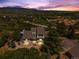 Stunning aerial view of a home with mountain views and lush landscaping at twilight at 2357 Oak Ridge Rd, Sedalia, CO 80135