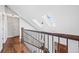 Bright hallway features hardwood floors, a decorative railing, and skylights for natural light at 2357 Oak Ridge Rd, Sedalia, CO 80135