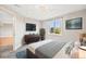 Serene main bedroom with a mounted TV, stylish furniture, and a bright window with outdoor views at 2357 Oak Ridge Rd, Sedalia, CO 80135