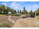 Secluded outdoor patio featuring stone pavers, a built-in grill and lush landscaping at 2357 Oak Ridge Rd, Sedalia, CO 80135