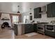 Modern kitchen features stainless appliances, dark green cabinets, white countertops, and a stylish backsplash at 2085 Krameria St, Denver, CO 80207