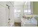 Bathroom featuring a shower-tub combo, marble countertop, and white subway tile at 3700 Miller St, Wheat Ridge, CO 80033