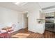 Eat-in kitchen featuring tile backsplash, wood-look floors, and small dining area at 3700 Miller St, Wheat Ridge, CO 80033