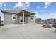 A backyard patio featuring a covered porch with an outdoor fire pit with stone surround, creating a cozy gathering space at 5584 Turnbury Cir, Elizabeth, CO 80107
