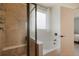 Bathroom featuring a shower stall, bathtub, and a window with white curtains that provide natural light at 5584 Turnbury Cir, Elizabeth, CO 80107